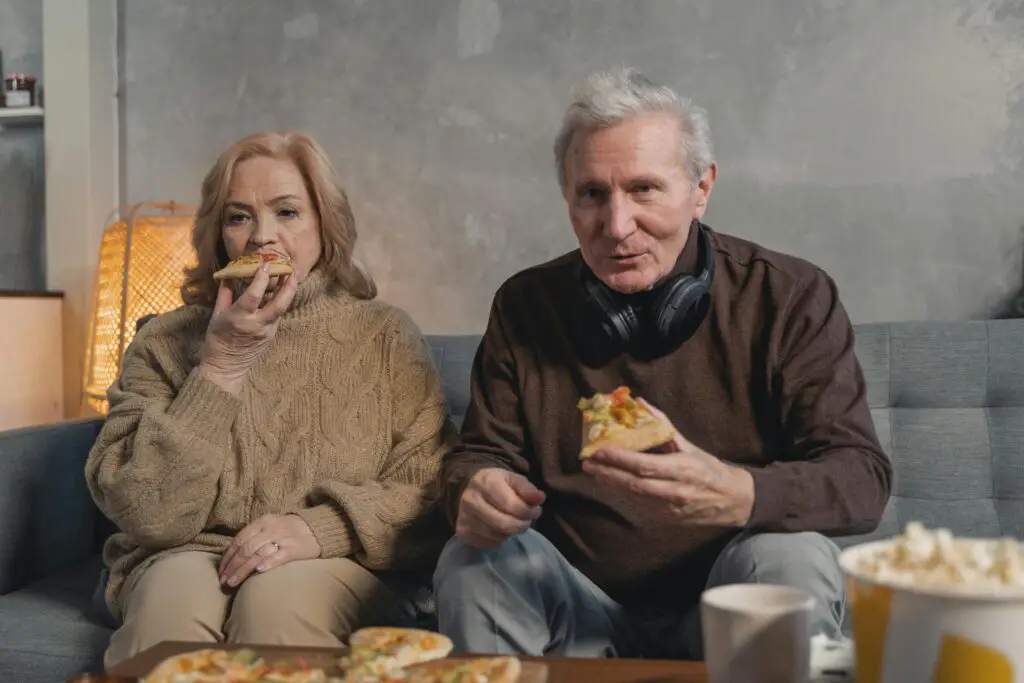 inadvisable way to tackle a pizza . a man a nd a woman eating pizza